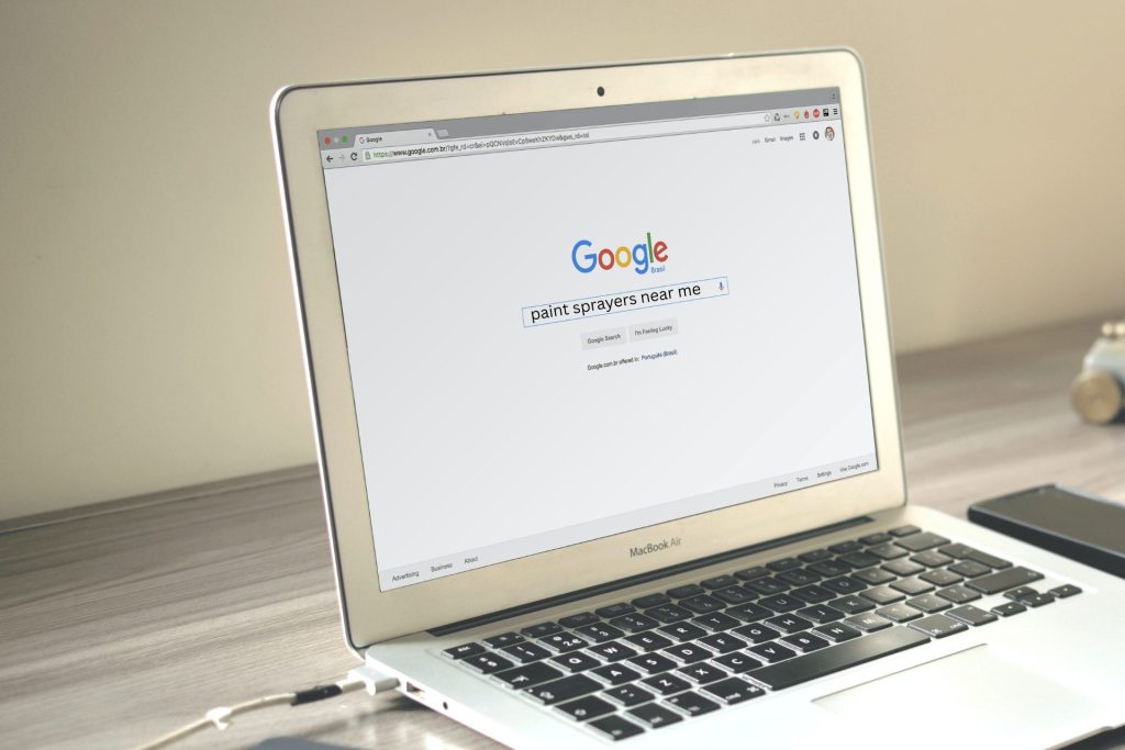 Someone searching on Google on a MacBook for paint sprayers near me