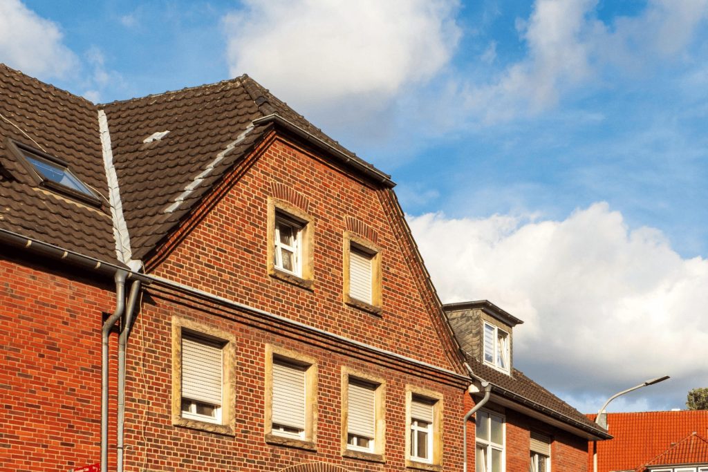 An image of faded gutters and downpipes in Swansea that need a spraying service